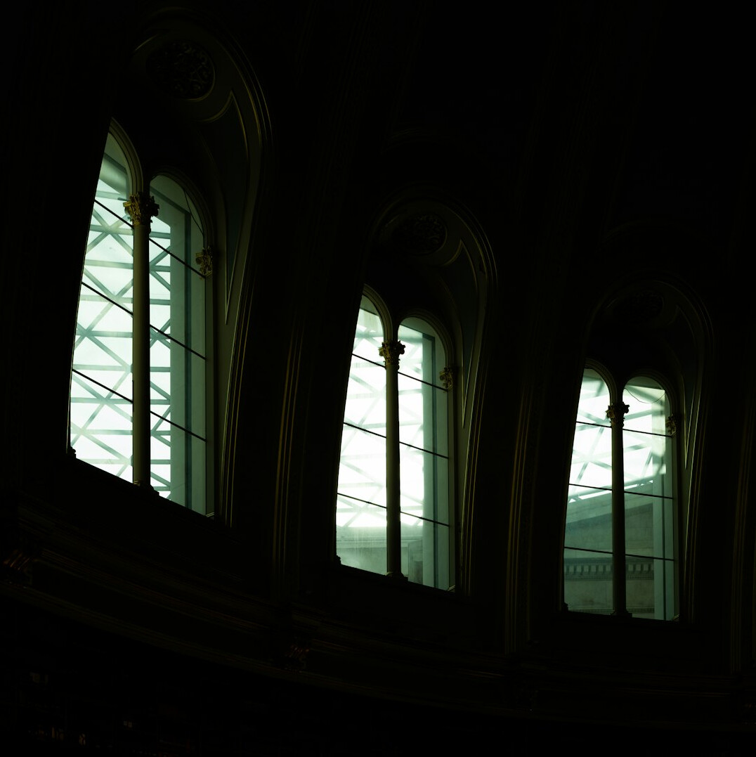Old library reading room with wooden shelves and reading lamps