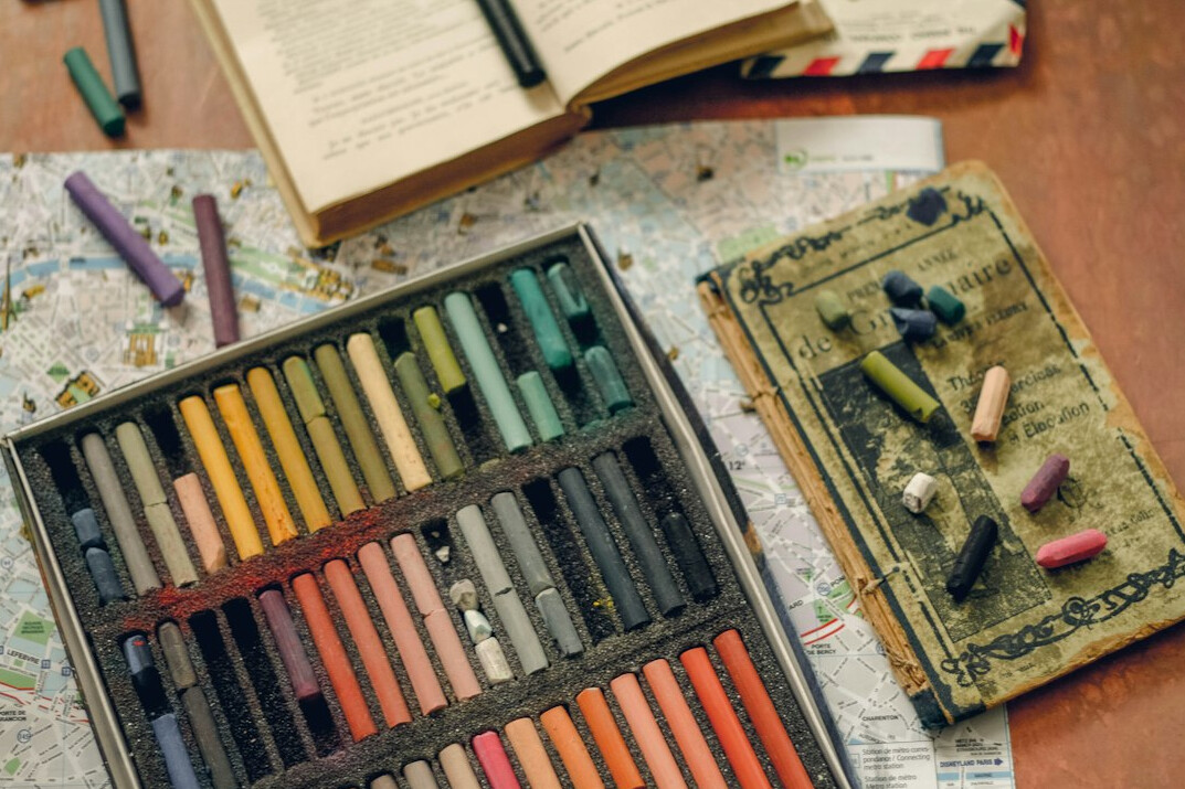 Open notebook with handwritten clues, pencils and a vintage map