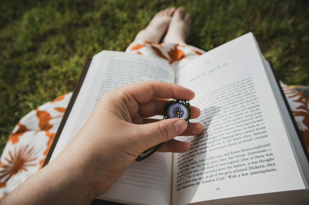 Open book with a magnifying glass on a dark wooden table