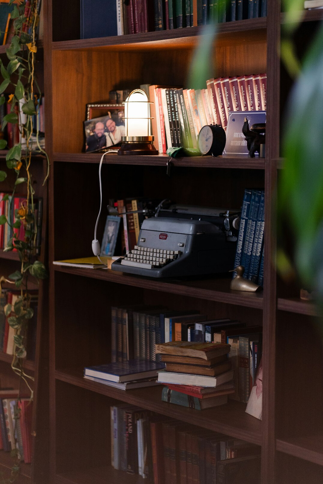 Vintage detective desk with magnifying glass, notebook and old typewriter under a warm lamp